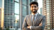© N7 - Indian Businessman in Front of Skyscrapers - A young Indian professional standing in front of tall buildings, looking confidently.