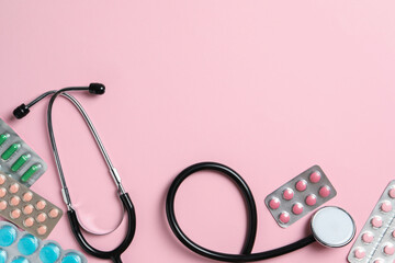 Poster - Stethoscope and pills on pink background, flat lay. Space for text