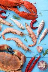 Poster - Different sea food on light blue wooden table, flat lay