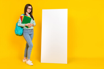 Poster - Full size image of brilliant charming university student stand near placard poster isolated on yellow color background