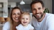 © Pinklife - A cheerful family poses together at home, featuring parents and their young daughter sharing a joyful moment, symbolizing family unity and happiness in a warm setting.