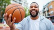 © Pinklife - A basketball player laughs heartily while spinning a ball on an urban court, epitomizing fun and friendship during a sunny day of sports amid city energy.