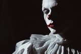 A scary evil clown portrait shot in a studio with horrible facial art