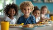 © Kittipong - A closeup perspective of a smiling boy with curly blonde hair focused on him with a blurred background of other children and food The boy is in a blue shirt and there is a yellow