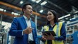 © Glce - The boss and the worker are in the factory, the boss is showing something on the tablet and they are both smiling.