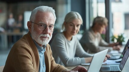 Senior entrepreneurs using digital devices for a startup project, grey-haired professionals working on a laptop, vibrant and diverse team of elderly businesspeople