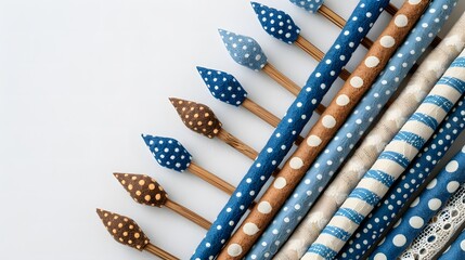 Polka dot fabric pencils in blue and brown shades arranged on a white background. Flat lay composition with copy space for craft, handmade, or creative design and marketing material