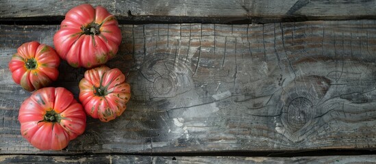 Wall Mural - Raw ripe pink heirloom organic tomatoes on a wooden surface Vegetarian Vegan healthy diet culinary cooking idea Top View. Copy space image. Place for adding text and design