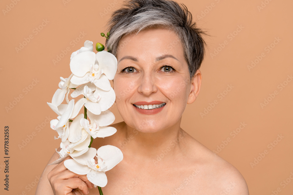 Photo of attractive naked shirtless female model mature woman holding orchid flower branch for