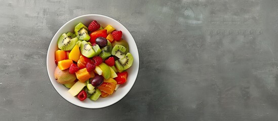 Poster - Bowl of fresh healthy fruit salad on a grey background Panorama banner with copyspace