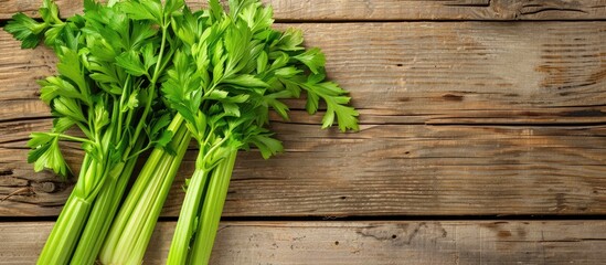 Poster - Celery leaves on a wooden background Top view Copy space