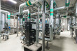 © alhim - A detailed view of an industrial facility reveals intricate piping systems and machinery arranged in a functional layout, indicating active operations throughout the day..
