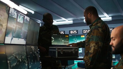 Poster - Air force officer performing tactical level surveillance in command room using laptop. Close up of military specialist in base of operations using radar on notebook to look at assault zones, camera B