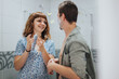 © qunica.com - A cheerful young couple in a bathroom preparing for a night out, enjoying playful conversation and sharing grooming products.