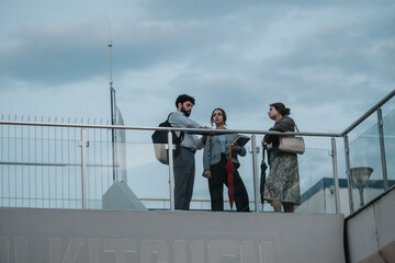 Wall Mural - Young business professionals meet outdoors to discuss marketing strategies and analyze reports, brainstorm ideas, and plan for company growth.