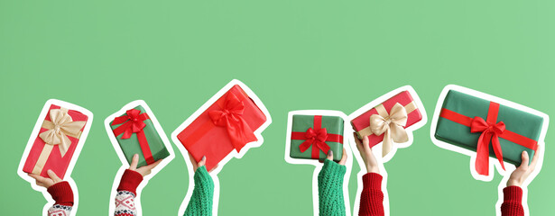 Female hands holding Christmas gift boxes on green background