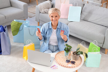 Poster - Mature woman with credit cards shopping online at home