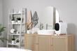 © Pixel-Shot - Small refrigerator with cosmetic products on cabinet in bathroom