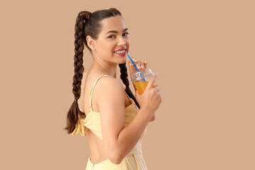 Canvas Print - Beautiful young happy woman with braids holding cup of tasty lemonade on beige background