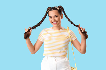 Poster - Beautiful young happy stylish woman with braids on blue background