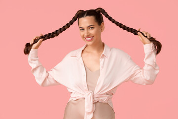 Wall Mural - Beautiful young happy stylish woman with braids on pink background