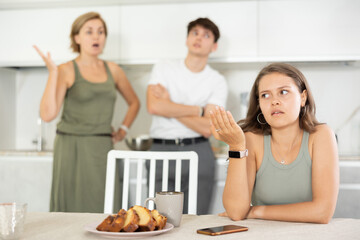 Canvas Print - Mother-in-law and son scold young daughter-in-law in the home kitchen