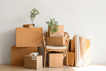 Poster - Armchair with cardboard boxes and things near light wall in room