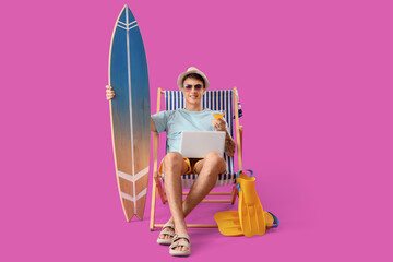 Canvas Print - Young man with cocktail, laptop and surfboard sitting in deck chair on purple background