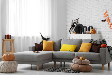 Sticker - Interior of living room with sofa, poufs and Halloween pumpkins