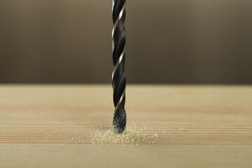 Poster - Drilling hole in wooden plank on grey background, closeup