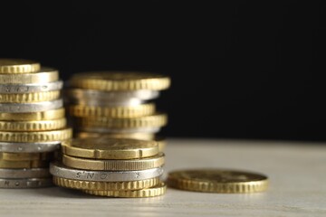 Wall Mural - Stacked coins on wooden table against black background, closeup with space for text. Salary concept