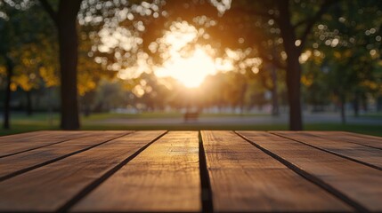 Poster - A wooden table in a park with a sunset in the background, evoking tranquility.