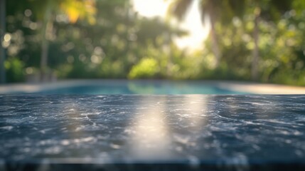 A blurred view of a poolside with a marble surface in focus, creating a serene atmosphere.