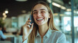 © Sajib - Young woman smiling while talking on the phone in a modern office during the day