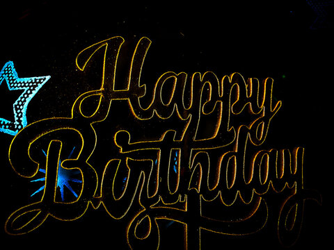 Happy birthday calligraphy on black background with decorated black balloons 