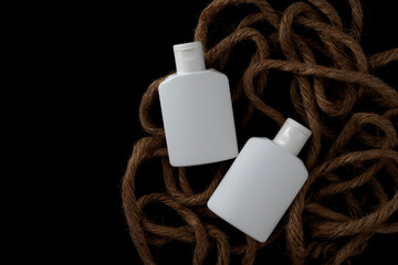 Two white plastic bottles on pile of ropes. For mockup.