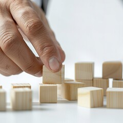 Wall Mural - Hand stacking wooden blocks on white background, business growth concept