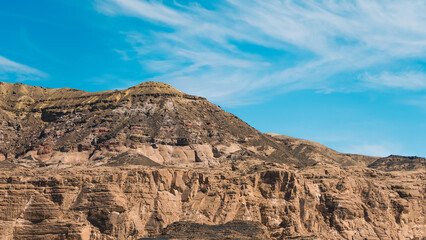 high rocky mountains in the desert against the blue sky and white clouds in Egypt Dahab South Sinai