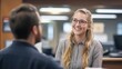 © Theeranan - A friendly bank employee smiling while discussing loan options with a customer in a modern bank office.
