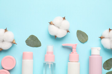 Poster - Different cosmetic products, leaves and cotton flowers on light blue background, flat lay