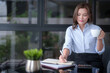 © snowing12 - Asian businesswomen drinking coffee and checking marketing business document to taking notes in notebook while working to analyzing investment and market stock of new startup in outside office