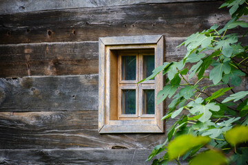 Old window on a wooden brown house