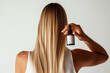 © World's Greatest Mom - Blonde woman holding a dropper bottle of beauty serum behind her head, showing long smooth hair
