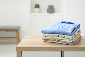 Canvas Print - Stack of clean clothes on wooden dresser indoors