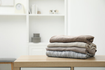 Canvas Print - Stack of clean clothes on wooden dresser indoors