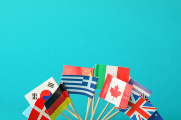 Canvas Print - Small paper flags of different countries on light blue background