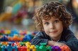 © sergiokat - Portrait of a child with autism playing with colorful building blocks, deeply focused and happy