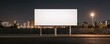 © ParinApril - A blank billboard stands illuminated at night in an urban environment, ready for advertising opportunities.