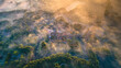 © AmazingAerialAgency - Aerial view of a beautiful fortress and windmill surrounded by fog and forest at sunrise, Bourtange, Groningen, Netherlands.