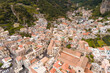 © AmazingAerialAgency - Aerial view of the beautiful historic town of Amalfi with medieval buildings and scenic mountain backdrop, Salerno, Italy.
